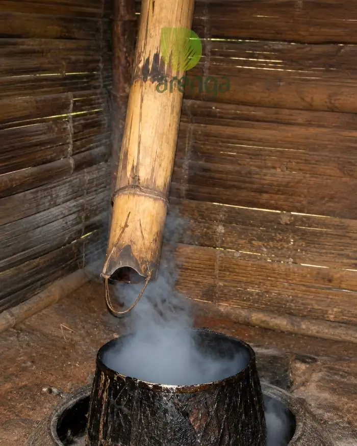 Cara sterilisasi lodong nira aren dengan metode pengasapan tradisional di atas tungku untuk menjaga kebersihan wadah penampung nira agar menghasilkan gula aren berkualitas.