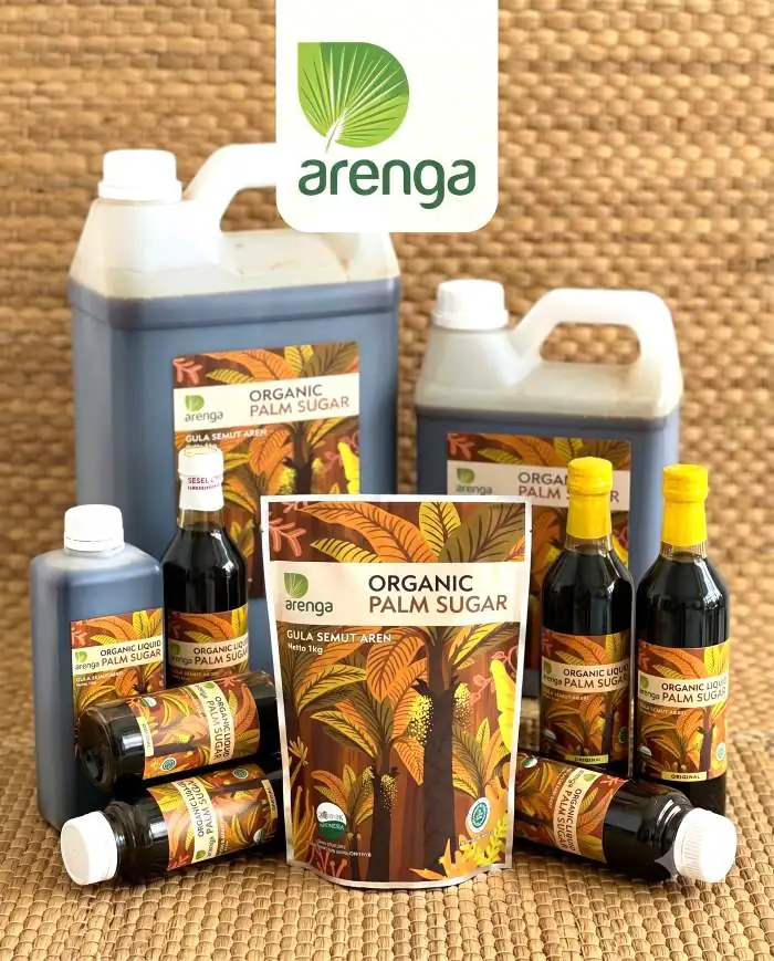 Foto produk yang menampilkan berbagai kemasan Gula Aren Cair Organik dan Versi Bubuk Arenga Indonesia, termasuk jerigen, botol, dan pouch bubuk, di atas tikar pandan tenun, dengan logo Arenga transparan. Ilustrasi visual untuk artikel: "Mana yang Lebih Bagus untuk Baking: Gula Aren Cair Organik atau Versi Bubuk?