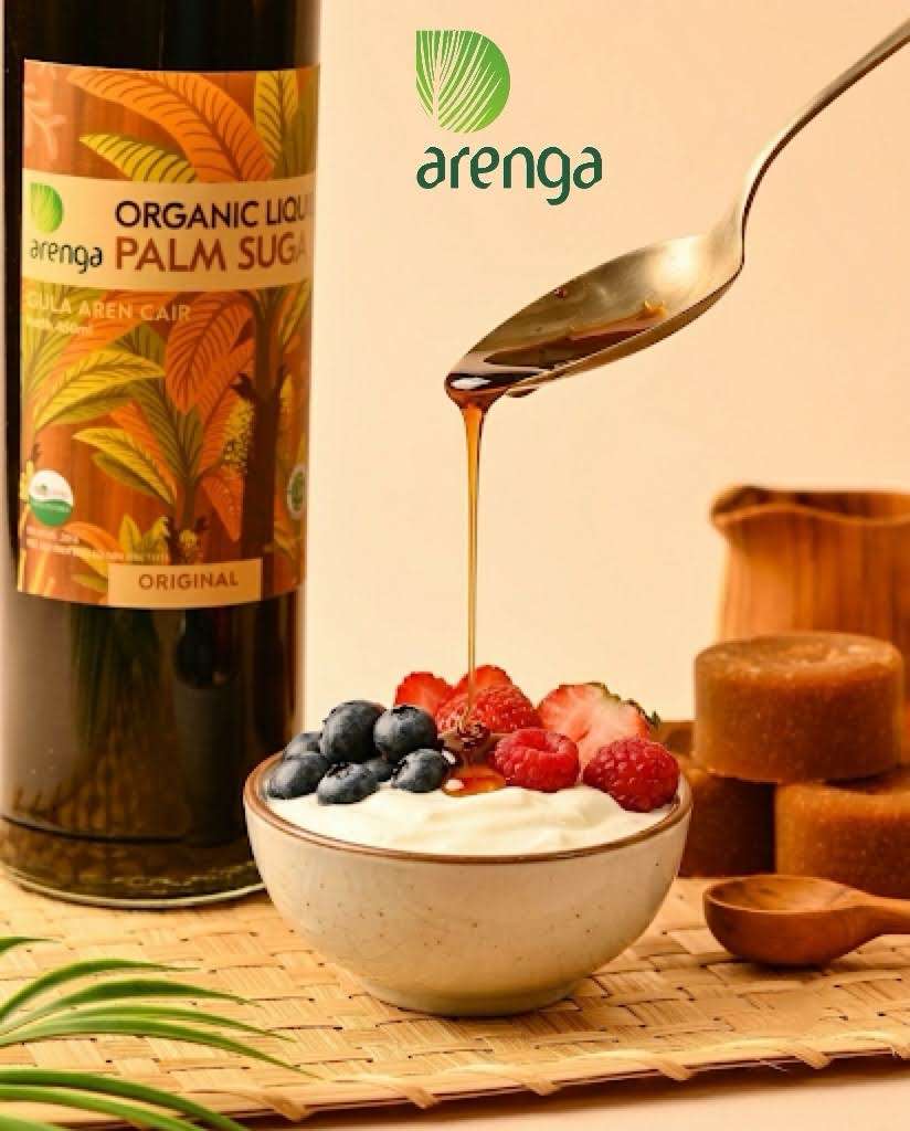 dessert sehat greek yogurt Sajian Resep Dessert Sehat: Greek Yogurt Beri Segar Penggugah Selera di dalam mangkuk keramik dengan taburan buah blueberry dan stroberi, disiram perlahan menggunakan gula aren cair dari atas sendok, berlatar belakang botol Arenga Organic Liquid Palm Sugar dan kepingan gula aren di atas alas anyaman.